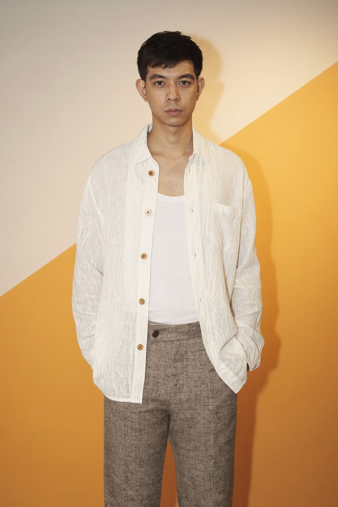 Reidel, the designer and developer behind Studio Reidel, standing against a two-tone cream and amber backdrop